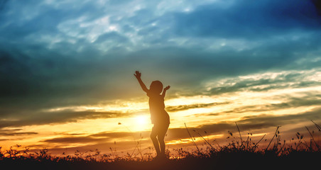 Silhouette of kid and the beautiful sky in the evening