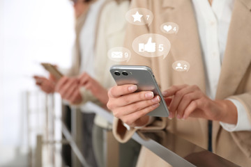 Young woman using modern smartphone indoors, closeup