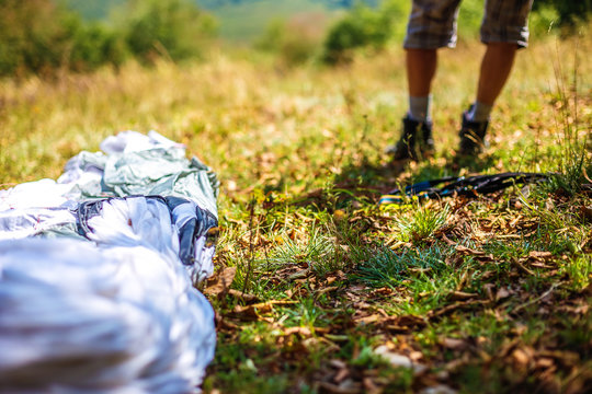 Paragliding in the mountains, paraglider on the ground.