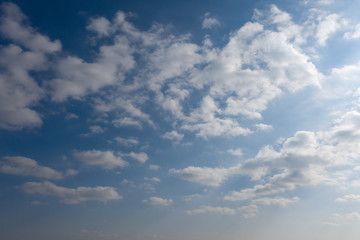 Fluffy white clouds on blue sky background.