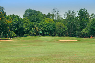 The evening golf course has sunlight shining down at golf course in Thailand