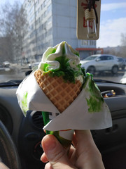 Ice cream in a waffle cone with green jam. Inside the car. The inscription translated from Chinese...