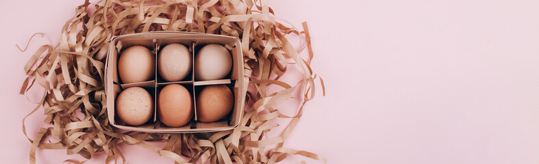 Banner made with Farm organic eggs in a wooden basket and paper pack decor on pastel pink...