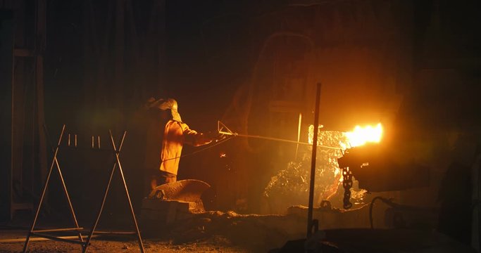 Hard work in a foundry. Metal smelting furnace in steel mill. Molten metal pouring, metallurgy, steel casting foundry. Steel manufacturing