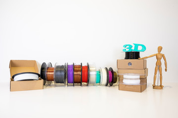 3D printing filament reels for 3d printers in boxes with wooden anthropomorphic doll with text 