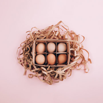 Farm Organic Eggs In A Wooden Basket And Paper Pack Decor On Pastel Pink Background. Zero Waste, Easter Concept. Flat Lay Style.