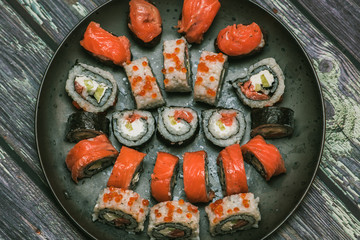Various kinds of sushi served on dark plate macro