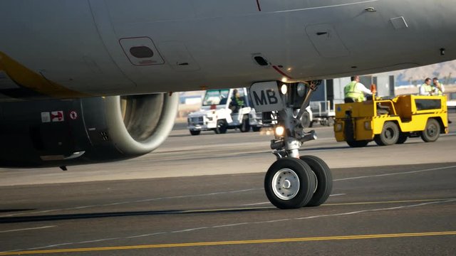 International airport. Front landing gear of airplane aircraft moves on the airport airfield 