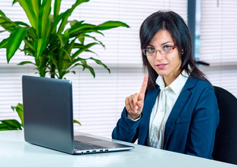 smart working. Young woman in front of pc notebook. Information technology. Attention gesture - 329779010