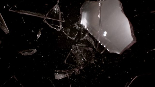 Shooting glass shatters in slow motion on black background