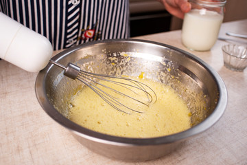 Beaten egg yolks in a bowl with whisk