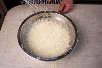 Beaten egg yolks in a bowl with whisk