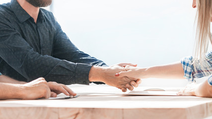employer shaking hands with a new employee during the interview