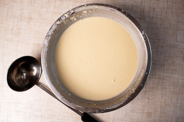Dough for crepes or pancakes in glass bowl top view