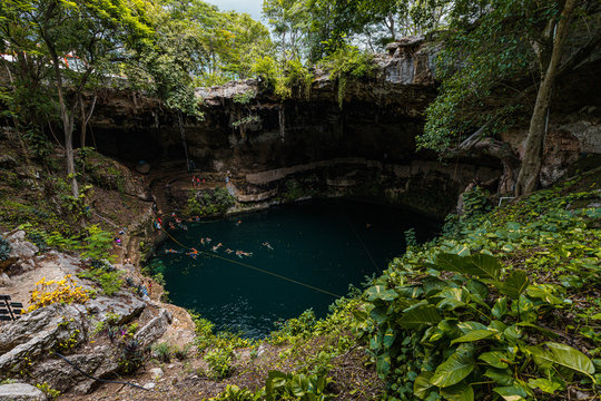 View into the crystal clear and blue water of a typical Mexican cenot (Zaci Cenote) in Valladolid near Cancun (Yucatan Peninsula, Mexico, America)