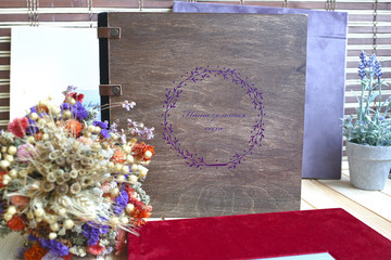 album photo book with  the inscription in a brown wooden cover with with a decor next to flowers