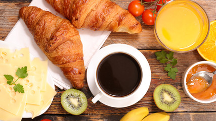 breakfast with coffee cup, orange juice, cheese and croissant