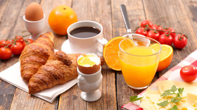 breakfast with coffee cup, orange juice, egg, cheese and croissant
