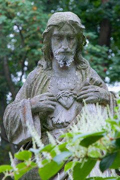 Jesus Christ with a heart in a crown of thorns. Anvient statue. Religion, Christianity, God, faith concept.