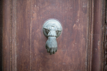 close-up view of an old metal door handle on a wood door