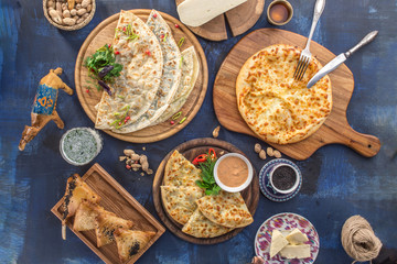 khachapui, dolma, cheburek and samsa assorted asian food appetizer on blue background