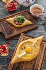 Traditional Georgian khachapuri bread with cheese and meat on wooden table