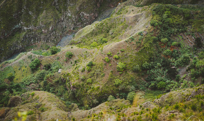 Santo Antao, Cape Verde. Mountain ridge with dry river bed of canyon with steep cliff and winding riverbed with lush green vegetation