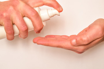 Man opens hand for disinfection to viruses. Use cream to clean hands.