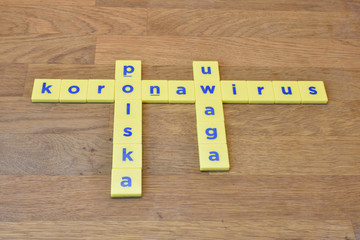 Koronawirus, Polska, Uwaga (translation from Polish language: Coronavirus, Poland, Warning), crossword plastic letters text on wooden background, concept about corona virus COVID-19 - 329788043
