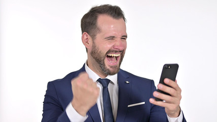 Portrait of Cheerful Young Businessman Celebrating on Smartphone, White Background