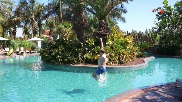 Man jumping into swimming pool in slow motion 180fps