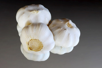 Garlic bulbs and garlic cloves on a mirror. Aromatic herb background.