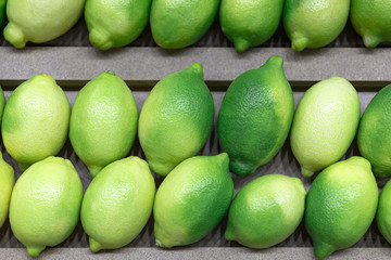 Green lemons on the counter in the store.