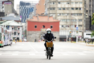 A Chinese man, wearing a face mask to protect himself from the novel coronavirus 2019-nCoV or COVID-19 is riding a scooter in Taipei, Taiwan.