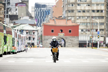 A Chinese man, wearing a face mask to protect himself from the novel coronavirus 2019-nCoV or COVID-19 is riding a scooter in Taipei, Taiwan.