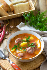 The concept of healthy and diet food, vegetarian dish. Delicious Vegetable soup with bean balls on a rustic table.
