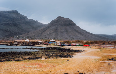 Baia Das Gatas. North of Calhau, Sao Vicente Island Cape Verde. Mysterious landscape of sandy coastline with fisher village and black volcanic mountains in background.