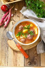 The concept of healthy and diet food, vegetarian dish. Delicious Vegetable soup with bean balls on a rustic table. Copy space.