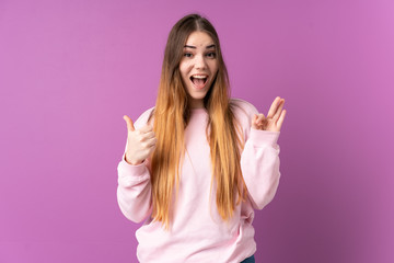 Fototapeta na wymiar Young caucasian woman isolated on purple background showing ok sign and thumb up gesture