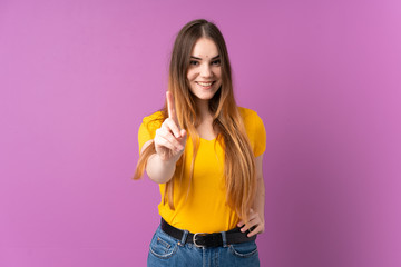 Young caucasian woman isolated on purple background showing and lifting a finger