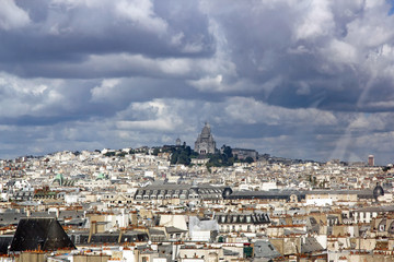 Fototapeta premium Les toits de Paris sous un ciel d'orage . Au loin le Sacré Coeur (Paris France)