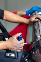 Car repair service, Afro American man working on glass replacement. Windshield insurance, safety and driving concept. Automotive industry.