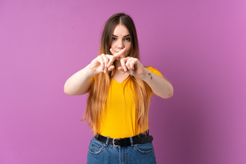 Fototapeta na wymiar Young caucasian woman isolated on purple background making stop gesture with her hand to stop an act