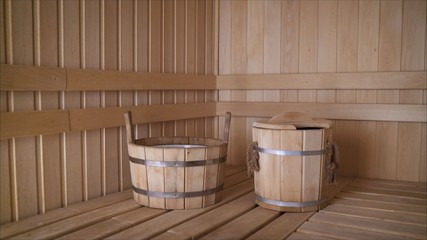 Fototapeta na wymiar Brooms with dried herbs in a wooden bath. Relaxation concept. Wooden dishes in the sauna
