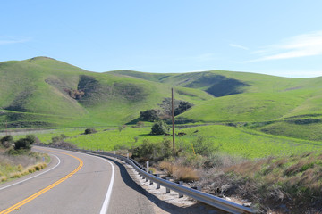 winding curved road bright mountain hillside blue sky