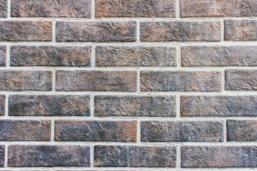 Texture of brick wall made of dark brown black bricks.