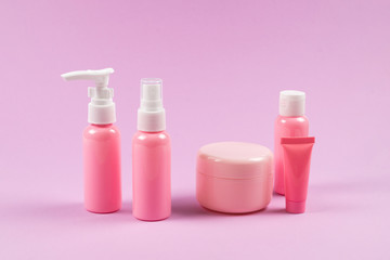 Pink plastic bottles for hygiene products, cosmetics, hygiene products on a pink background.