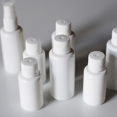 White vials and jars for medicines and tablets on a white background. Medicine. Virus. Antibiotics