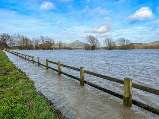 Wooden fence and farmland under water as a result of the River Severn bursting its banks after heavy rain
