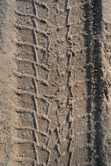 Print of wheel on a sand surface.